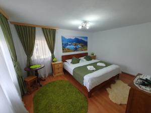 sypialnia z łóżkiem i zielonym dywanem w obiekcie Belvedere La Cristina w mieście Corbeni