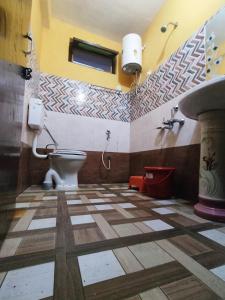a bathroom with a toilet and a sink at Shree Om Nanda Rudra Hotel Chaukori Pithoragarh in Chaukori
