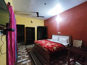 a bedroom with a bed with a red wall at Shree Om Nanda Rudra Hotel Chaukori Pithoragarh in Chaukori