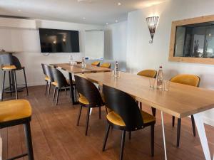 - un restaurant avec des tables et des chaises en bois dans une chambre dans l'établissement LOGIS HOTEL - La Petite Rade, au Havre