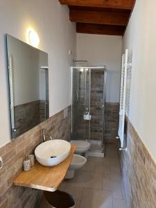 łazienka z 2 toaletami, umywalką i prysznicem w obiekcie B&B Torre Sibissi Bari w mieście Triggiano