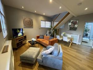 ein Wohnzimmer mit einem Sofa und einem TV in der Unterkunft Luxury 3-bed Victorian Townhouse Hosted by Hutch Lifestyle in Leamington Spa