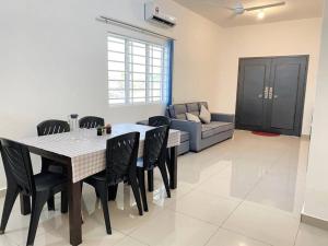 a dining room with a table and chairs and a couch at A Cool place to stay in Seremban