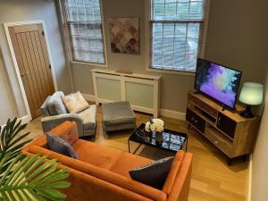 a living room with a couch and a tv at Luxury 3-bed Victorian Townhouse Hosted by Hutch Lifestyle in Leamington Spa