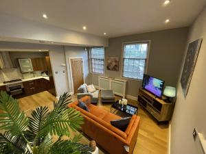a living room with a couch and a tv at Luxury 3-bed Victorian Townhouse Hosted by Hutch Lifestyle in Leamington Spa