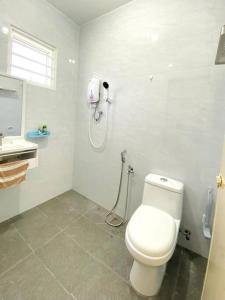 een badkamer met een toilet en een telefoon aan de muur bij A Cool place to stay in Seremban