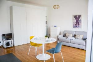 a living room with a table and chairs and a couch at Mysa Properties - Ampio monolocale in zona Bande Nere in Milan