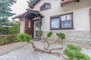 une maison avec une branche d'arbres devant elle dans l'établissement Gościniec na Leśnej, à Sztutowo