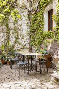 I gerani rossi في Paulilatino: طاولة وكراسي أمام المبنى