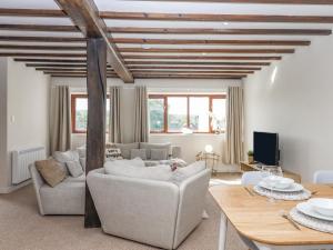 a living room with a couch and a table at Rose Cottage at Treaslake Farm in Honiton