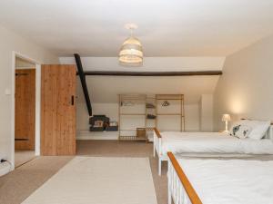a bedroom with two beds and a closet at Rose Cottage at Treaslake Farm in Honiton