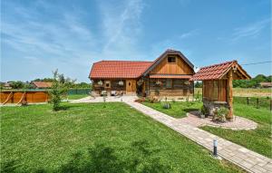 ein Blockhaus mit einem roten Dach und einem Hof in der Unterkunft Cozy Home In Lonjica With Kitchen in Gračec