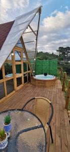 a deck with a hot tub and a table and chairs at Glamping Villa Gilma in Sevilla