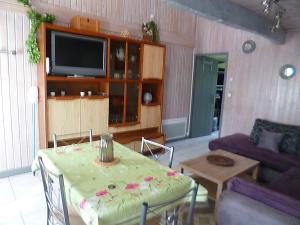 a living room with a table and a television at gite du guip in Trégourez