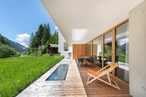 a house with a deck with a table and chairs at Greva Apartments 2 in Santa Cristina in Val Gardena