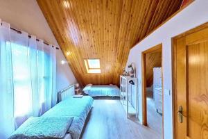 1 dormitorio con 2 camas y techo de madera en Casa Algarri - tucasaenlospirineos, en Escarrilla