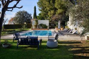 a swimming pool with lounge chairs next to a house at Torre Lolita - House in Lleida for 8 with pool and tennis court in Lleida