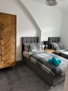 a bedroom with a large bed and a dresser at Clare Street - 3 bedroom house with private parking in Merthyr Tydfil