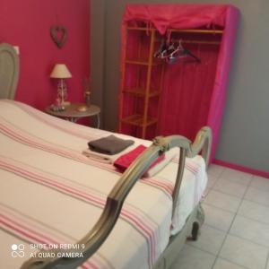 ベルガルドにあるLa maison du paradisのピンクの壁のベッドルーム1室