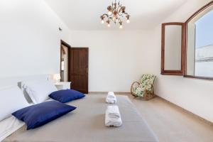 een slaapkamer met 2 bedden met blauwe kussens en een kroonluchter bij Villa Ninnedda in SantʼAndrea