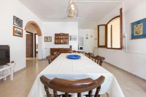 een eetkamer met een witte tafel en stoelen bij Villa Ninnedda in SantʼAndrea