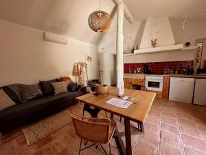 een woonkamer met een tafel en een bank bij Mas des Bambous in Saint-Rémy-de-Provence