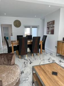 uma sala de estar com uma mesa de jantar e cadeiras em Clare Street - 3 bedroom house with private parking em Merthyr Tydfil