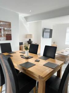 a dining room table with chairs and a wooden table at Clare Street - 3 bedroom house with private parking in Merthyr Tydfil
