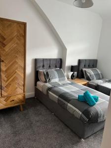 a bedroom with a large bed and a dresser at Clare Street - 3 bedroom house with private parking in Merthyr Tydfil