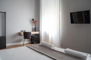 Nolana 28 Rooms in Naples في نابولي: غرفة مع سرير وتلفزيون على الحائط