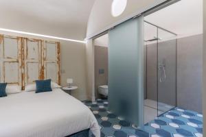 カターニアにあるBiuti Suite Apartmentのベッドルーム1室(ベッド1台、ガラス張りのシャワー付)