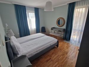 a bedroom with a bed and a desk in it at Flowers Apartments in Nesebar