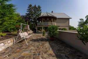 a house with a gazebo on a patio at Belvárosi Nemes Apartmanház Szekszárd in Szekszárd