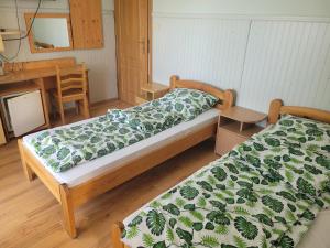 two beds in a room with a table and a desk at Willa Westa in Mielno