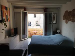 Schlafzimmer mit einem Bett und Blick auf einen Innenhof in der Unterkunft Studio tout confort centre ville - Balcon, Clim, TV, Wifi in Mazan