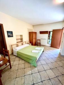 a bedroom with a large bed with a green blanket at Affittacamere Porta Majella in San Valentino in Abruzzo Citeriore