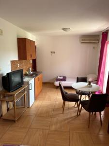 a living room with a kitchen and a table with chairs at Guest House Andrea in Budva