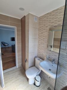 a bathroom with a toilet and a sink at Flowers Apartments in Nesebar +43 photos