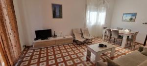 sala de estar con sofá, TV y mesa en Villa Ecnomo, en Licata