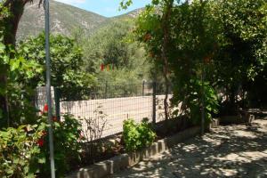 a fence in a garden with mountains in the background at Grapes and Roses in Igoumenitsa