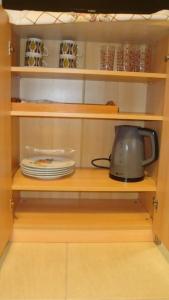 a cupboard with a tea kettle and plates in it at Grapes and Roses in Igoumenitsa