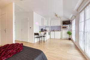 um quarto branco com uma cama e uma cozinha em Life in Pink - Près Paris/CDG/Bourget/Parc expo em Drancy