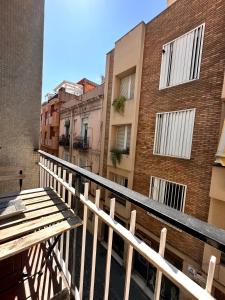 een balkon met een houten bank en gebouwen bij Gracia Barcelona Apartment in Barcelona