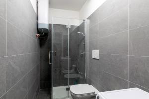 a bathroom with a toilet and a glass shower at Botique Apartment • Trieste City Center [Wifi] in Trieste +10 photos