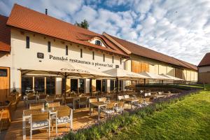 a restaurant with tables and chairs in front of a building at Posedy Panský dvůr Telč in Telč