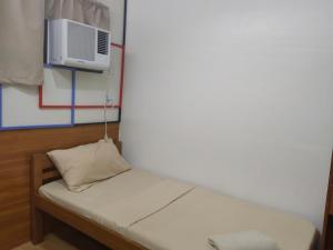 a small room with a bed with a air conditioner at Mansion 8 Residences in Roxas City