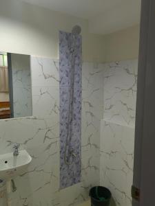 La salle de bains est pourvue d'une douche et d'un lavabo. dans l'établissement Mansion 8 Residences, à Roxas City