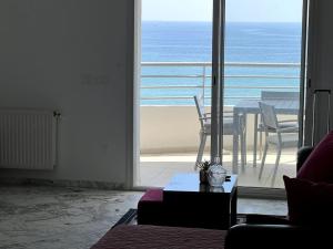 Sala de estar con mesa y vistas al océano en Résidence Le Monaco Sousse en Sousse