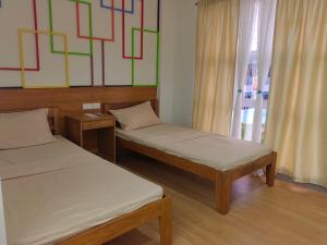 Cette chambre comprend 2 lits et une fenêtre. dans l'établissement Mansion 8 Residences, à Roxas City