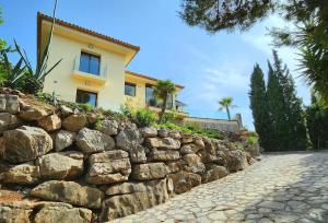 uma parede de pedra em frente a uma casa em Exclusive Villa at La Sella Resort em Pedreguer